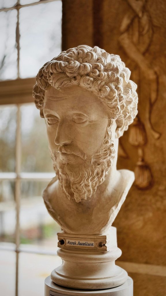A marble bust of a Roman emperor in soft window light